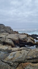 Breathtaking view of Chile’s Pacific coast, featuring rugged rocks, golden sandy beach, and waves under a bright sky. Perfect for travel, nature, and coastal landscapes.