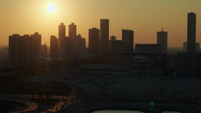 Sanabis district, Manama, Bahrain. Aerial view of highrise buildings backlit by setting sun