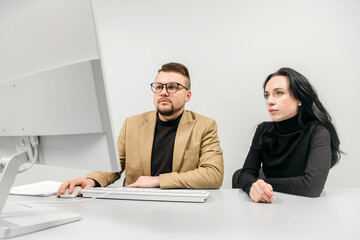 Two generalist business analysts discuss data management using computer. Conceptual consulting,...