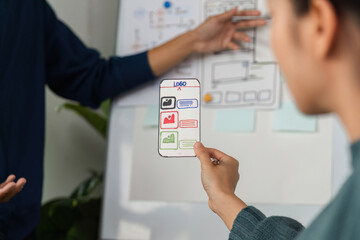 Design Collaboration and Creative Development. A team member presents a mobile app prototype to colleagues.
