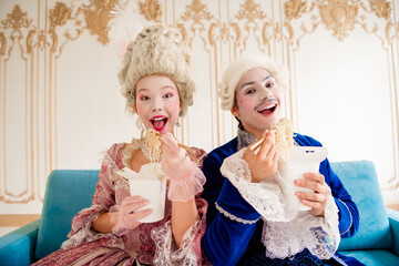 A couple in elegant baroque costumes enjoying takeaway noodles in a luxurious palace setting with...