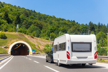 Scenic view big modern white family rv camper van vehicle drive Europe highway road alpine mountain cloud in summer day. Rving motorhome lifestyle travel and adventure tourism trip journey concept