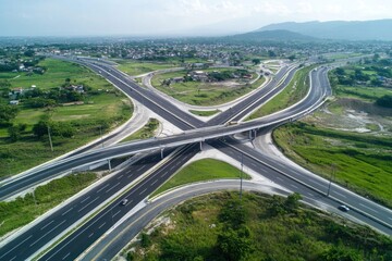 aerial view of highway interchange with multiple lanes and exits surrounded by green landscape. urban infrastructure development. transportation, city planning, travel guide, construction project.
