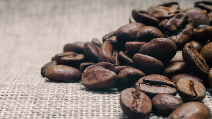 heap of roasted coffee beans on a matting macro