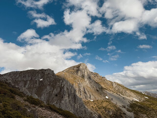Hikers trek through the scenic Mavrovo National Park, surrounded by majestic mountains and dynamic cloud patterns, showcasing the beauty of North Macedonia in autumn