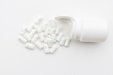 A subtle and clean image of candy pills emerging from a bottle, ideal for wellness and pharmaceutical branding.