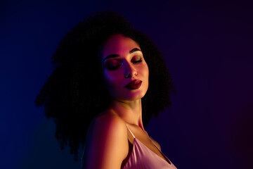 Portrait of a beautiful young woman with curly hair in vibrant neon lighting, showcasing elegance