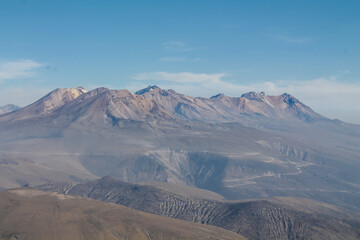 Naklejka premium Volcanic desert landscape of Andes mountains in South America. High mountain summit in the middle of desert high altitude altiplano, volcano El Misti crater near Arequipa city in Peru. Volcanic land