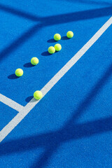 racquet sport, seven padel balls on blue paddle tennis court background