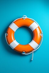 A vibrant orange lifebuoy against a bold turquoise background, symbolizing safety and rescue at sea.