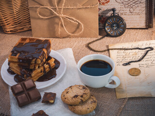 Chocolate waffles with coffee, cookies, and vintage pocket watch