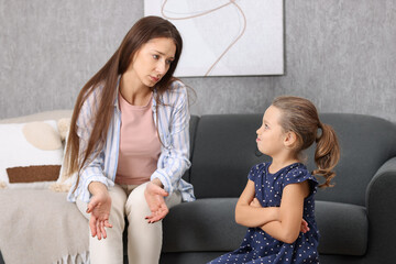 Resentful little girl and her mother arguing at home