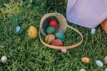 Colorful Easter Eggs Spilled from a Basket on Green Grass