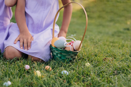 Child with easter basket full of colorful eggs outdoors