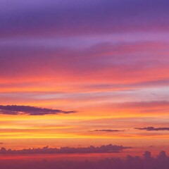 Fototapeta premium A stunning sunset sky with vibrant orange, pink, and purple hues blending together, soft clouds scattered across the horizon.