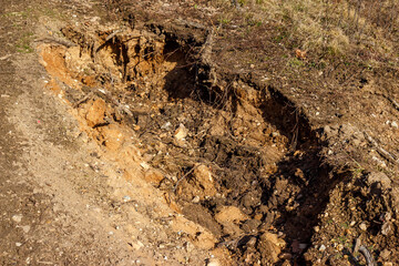The sandy slope has been eroded by the action of water, resulting in soil erosion