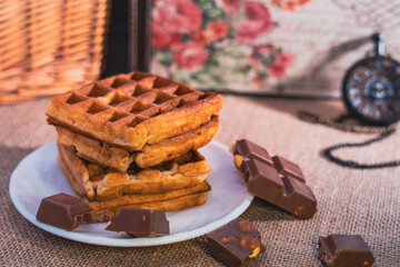 Rustic still life with waffles, chocolate, and pocket watch
