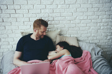 Red haired single father works with laptop