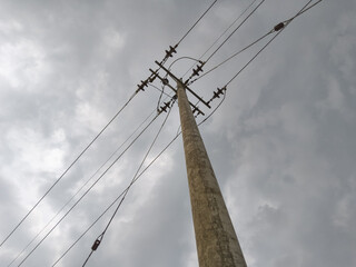Network of electric cables on electric poles, with a cloudy sky in the afternoon with low angle photo.