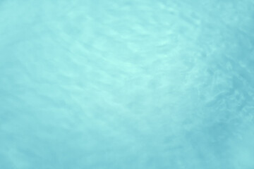 Background with clear blue water. Top view, copy location, text location. Blurred background, transparent water surface with splashes and wave texture with ripples
