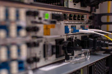 A close-up of a fiber optic network module with LC connectors plugged into high-speed networking equipment. The structured cabling ensures efficient data transmission in a data center environment