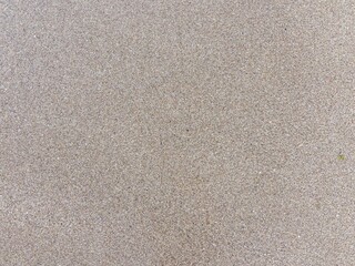Detailed view of sandy beach texture showcasing fine grain patterns and natural colors
