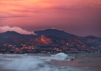 wavy sea withe the hills and city of Malaga as background