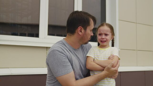 Father comforting his crying daughter, upset little girl with teary eyes, dad and daughter emotional moment, parent supporting sad child, family love and care, child experiencing sadness, emotional