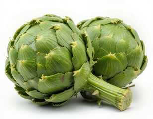 Obraz premium Two Fresh Green Artichokes on White Background Ready to Be Cooked