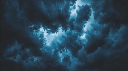 Dramatic dark blue stormy cloudscape, moody atmospheric background texture. Image ideal for design projects.
