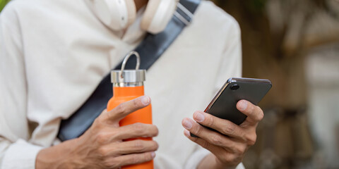 Sustainability and Urban Mobility. A person holds a reusable water bottle while engaging with a...