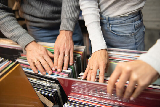 A man and a woman choose vinyl records.  Buying vinyl record.