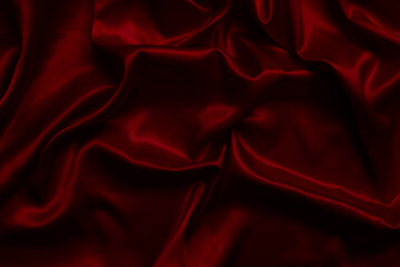 The top view of the red satin surface looks luxurious and beautiful. with sparkling waves Abstract background design copy space Card or banner (blurred or blurry)
