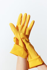 Yellow rubber gloves in woman's hands on white background