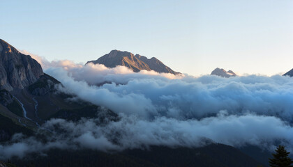 Misty mountains at dawn with sunlight peeking through, serene beauty