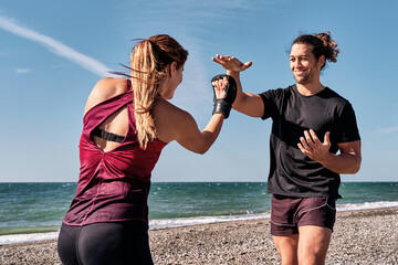 Athletes training mma on the beach, practicing punches and defense techniques