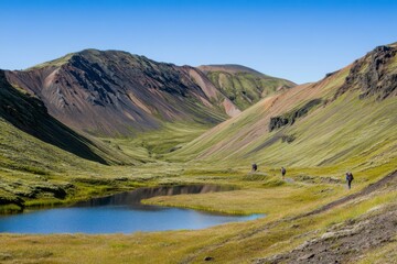 Fototapeta premium colorful mountains in Iceland, a grassy valley with a small lake and some hikers