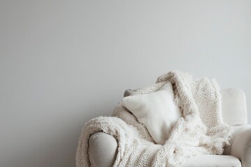 Obraz premium Armchair with a Cozy Blanket and Pillow Creates a Relaxing Mood