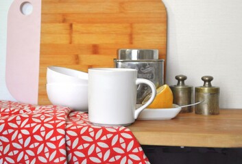 Kitchen with wooden cutting board, mug, bowls, lemon and weights