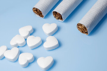 The medical concept of diseases of the human cardiovascular system. Cigarettes and a pill in the shape of a heart. Selective focus