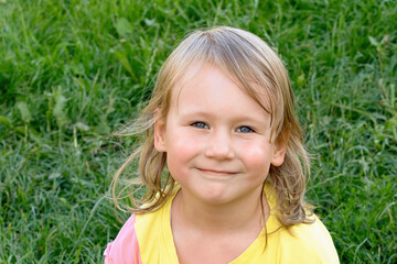 Portrait of a child, a 4-5-year-old girl on a summer day in nature.