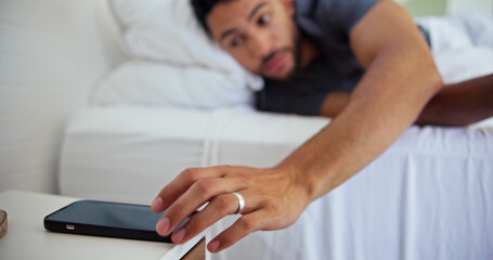 Man, bed and hand with phone alarm for morning routine, start day and wake up in home. Sound alert,...