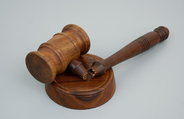 Broken wooden judge gavel on gray background. Injustice concept.