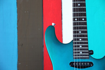 Obraz premium Vibrant Electric Guitar Against Colorful Wooden Background