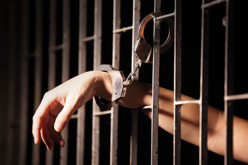 Gripped Handcuff on Prison Bars Symbolizing Captivity and Justice