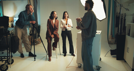 Photographer, review and tablet with people in studio together for discussion, photoshoot or...