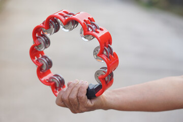 Close up hand hold  the tambourine. Concept, playing musical instrument. Shake for the rhythm of music and songs for entertainment.                               
