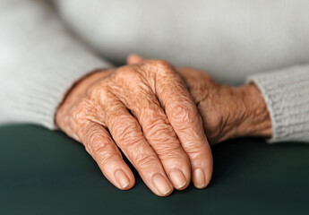 Fototapeta premium Close-up of elderly hands resting on each other, aging, care and wisdom concept with natural skin texture