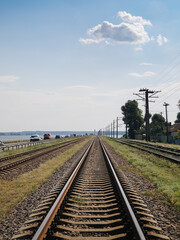 Causeway with straight stretch of railroad tracks. Diminishing perspective view of railway line in...