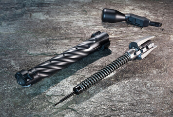 Black fluted rifle bolt that's been field stripped apart for cleaning